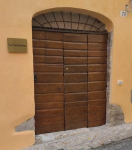 a wooden door in a building with an archway at La Ponzianina in Spoleto