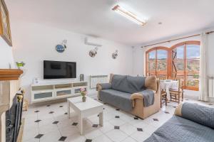 a living room with a couch and a tv at Casa rural VISTABLANCA en una sola planta con bonitas vistas y piscina - Junto a la capital y la Alhambra in Cenes de la Vega