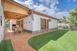 a house with a patio and a green lawn at Casa rural VISTABLANCA en una sola planta con bonitas vistas y piscina - Junto a la capital y la Alhambra in Cenes de la Vega