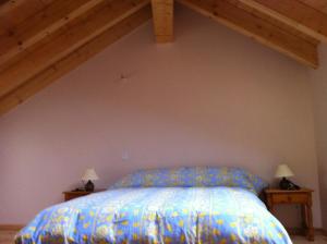 una camera da letto con un letto con un piumone blu di Maison De Caractère En Pierre cal Batlle a Saint-Pierre-dels-Forcats