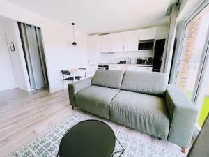 a living room with a couch and a table at ModernCosy Près Disneyland Paris in Noisy-le-Grand