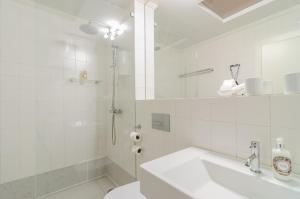 a white bathroom with a shower and a sink at Casa Morgado Esporao in Évora +38 photos