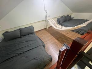 a bedroom with two beds and a hammock at Amnis Tiny House in Bachok