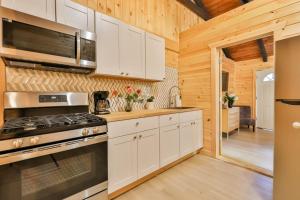 a kitchen with white cabinets and a stove at Matterhorns Hunter Lodge in Hunter