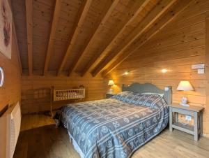 a bedroom with a bed in a log cabin at Le Grand Chalet Bellevue - parking Wifi BBQ in La Bresse
