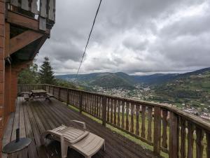 a wooden deck with a bench and a table on it at Le Grand Chalet Bellevue - parking Wifi BBQ in La Bresse