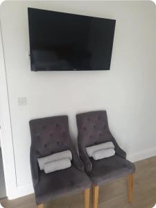 a chair with two towels and a television on a wall at Country Home in Ratoath +1 photo