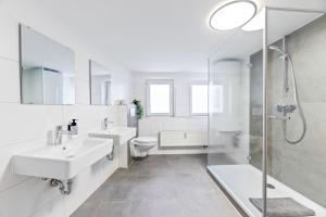 a white bathroom with two sinks and a shower at Perfekt für Firmen und Gruppen - 1 Haus, 2 XXL Wohnungen in Göppingen +49 photos