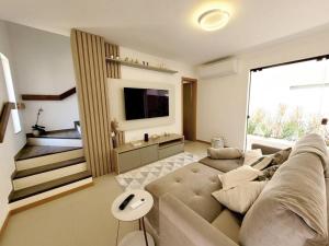 a living room with a couch and a large window at Bangalô Exclusivo A6 Imbassaí Privilege Beira Mar in Imbassai
