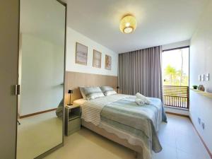 a bedroom with a bed and a large window at Bangalô Exclusivo A6 Imbassaí Privilege Beira Mar in Imbassai