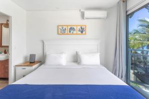 马霍礁Maho Beach House - Petite Studio - Ocean View的卧室里有一张白色的大床，床边有一扇窗户 更多3张照片