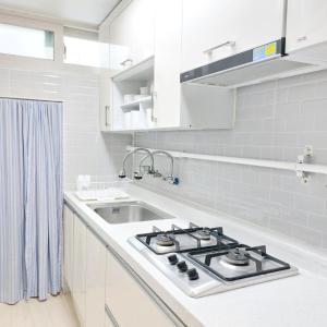 釜山にあるKen Houseのコンロとシンクのある白いキッチン