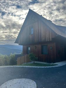 a large wooden house with a gambrel roof at Wellnessalmhaus in Kloster