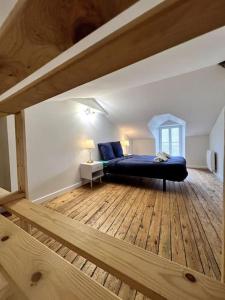 a bedroom with a bed and a wooden floor at Puy duFou 15 min T3 L'étape du Panache in Sevremont