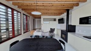 a dining room with a table and a living room at Almoxarife Beach House in Praia do Almoxarife