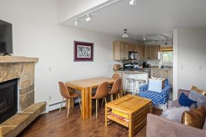 a living room with a table and a fireplace at Telluride Resort View at Double Diamond - ski-in-out and hot tub! in Telluride