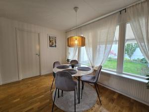 a dining room with a table and chairs and a window at Modern and complete House in Västerås