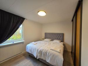 a bedroom with a large bed with a window at Modern and complete House in Västerås