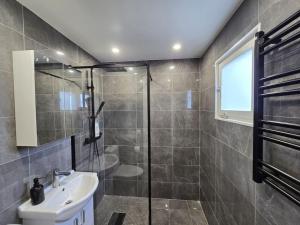 a bathroom with a glass shower and a sink at Modern and complete House in Västerås +44 photos