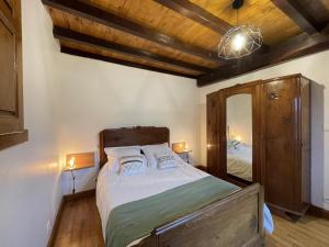 a bedroom with a large bed and a mirror at Loustaou in Osserain-Rivareyte