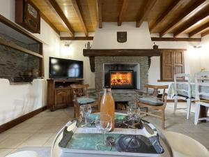 a living room with a fireplace and a table with wine glasses at Loustaou in Osserain-Rivareyte