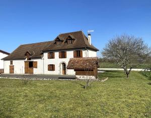 a large white house with a brown roof at Loustaou in Osserain-Rivareyte