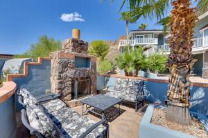 阿帕奇章克申Patio with Desert Views Apache Junction Abode的庭院设有石制壁炉、桌子和椅子。