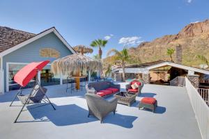 un patio con sillas y una sombrilla roja en Pool with Slide and Playground Arizona Group Getaway!, en Apache Junction