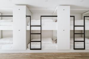 a room with four bunk beds with mirrors at The Salty Pelican Yoga & Surf Retreat in Peniche
