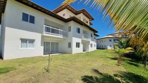 a large white house with a yard at Garden Térreo 3 Quartos Piscinas Naturais in Praia do Forte +37 photos