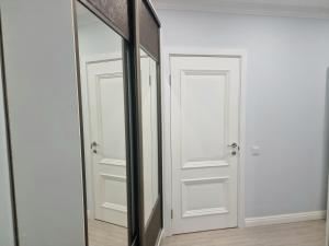 Un espejo en una habitación con dos puertas blancas. en Botanical Garden Park Apartment, en Chişinău