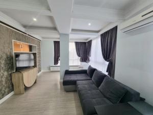 Una sala de estar con un sofá y un televisor de pantalla plana. en Botanical Garden Park Apartment, en Chişinău