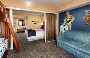 a bedroom with a bed and a couch in a room at Anaheim Portofino Inn & Suites in Anaheim