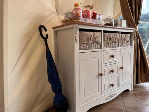 a white cabinet with an umbrella next to it at Oasis Inn Glamping in Panjadakan