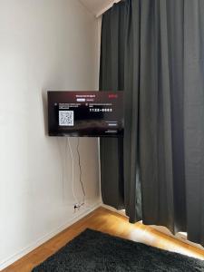 a television hanging on a wall next to a curtain at 2 hengen unikkosuite in Rovaniemi +6 photos