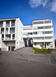 a white building with a parking lot in front of it at 2 hengen unikkosuite in Rovaniemi