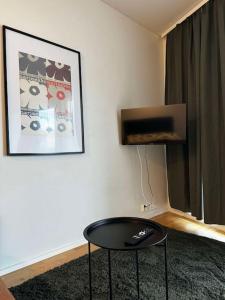 a living room with a table and a television at 2 hengen unikkosuite in Rovaniemi