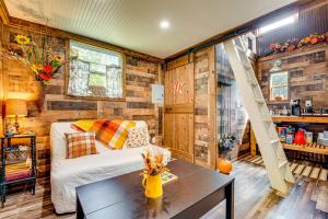 1 dormitorio en una cabaña de madera con 1 cama y 1 mesa en Creek Access, Fire Pit and Grill Summerville Studio, en Summerville