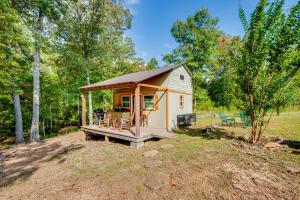 un pequeño cobertizo con un porche en un campo en Creek Access, Fire Pit and Grill Summerville Studio, en Summerville