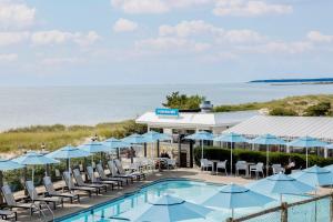 a pool with chairs and umbrellas next to the ocean at Blue Water Resort in South Yarmouth