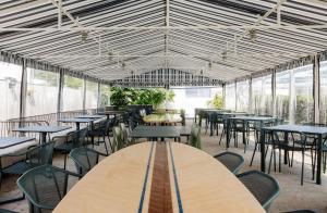 a dining room with tables and chairs and windows at Blue Water Resort in South Yarmouth