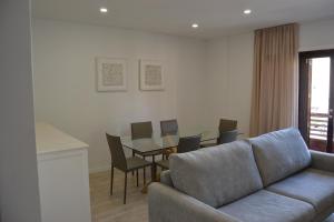 Una sala de estar con un sofá, una mesa y sillas. en Araucaria3, en La Laguna 12 fotos más