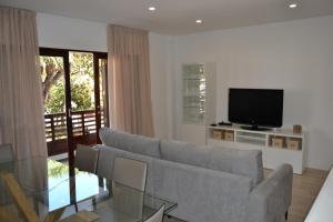 Una sala de estar con un sofá y un televisor. en Araucaria3, en La Laguna