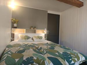 1 dormitorio con 1 cama con colcha frondosa en Nid douillet avec vue cathédrale, en Digne-les-Bains