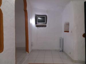 a bathroom with a tv on a wall at Casa cueva primera línea de playa en Sardina in Gáldar