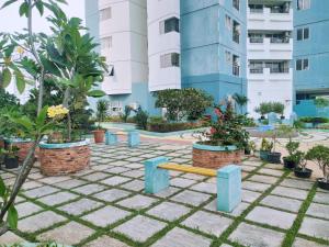 a park with a bench and trees and buildings at Green Central 1BR Apartments - Hayam Wuruk in Jakarta
