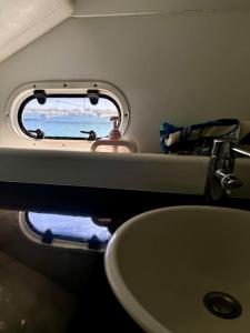 ein Badezimmer mit Waschbecken und Fenster in der Unterkunft Barco apartamento in El Portil