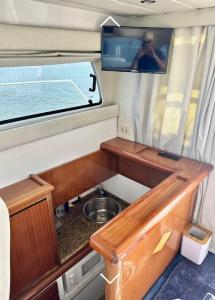eine kleine Küche mit Spüle und Fernseher in einem Wohnmobil in der Unterkunft Barco apartamento in El Portil