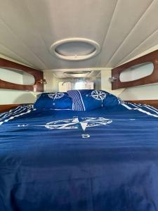 a large blue bed in the middle of a boat at Barco apartamento in El Portil