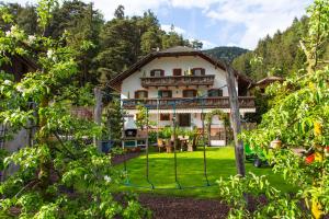 una casa en las montañas con un patio en Residence Obermoarhof - comfortable apartments for families, swimmingpool, playing-grounds, Almencard, en Vandoies